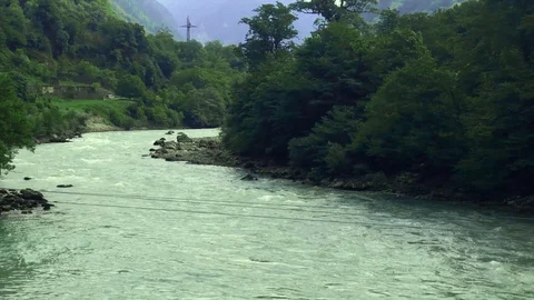 Panorama of a fast mountain river flowing among mountains overgrown with trees Stock Footage 128687476
