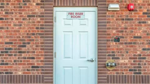 Panorama Fire Riser Room sign on the white wood door of a building with red Stock Photos