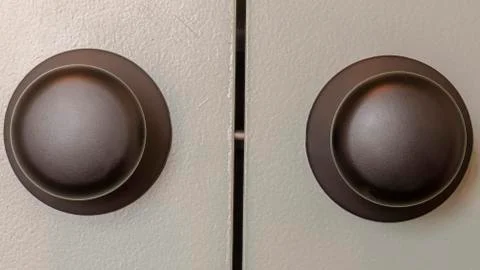 Panorama frame Close up view of matte black round door knobs of a gray bedroom Stock Photos