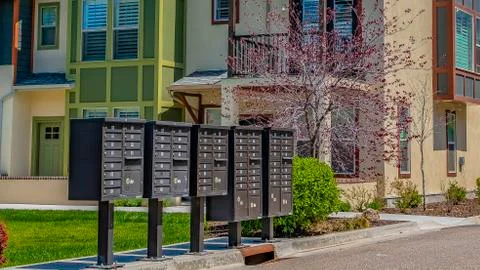Panorama frame Cluster mailboxes on the sidewalk in front of houses viewed on a Stock Photos