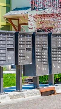 Panorama frame Row of cluster mailboxes with numbered compartments on a sunlit Stock Photos