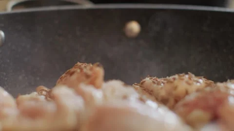 Panorama on a frying pan and cumin seasoning is sprinkled. The hand adds cumin Stock Footage 256300724