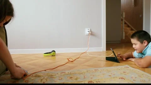 Panorama of girl on green sofa using smartphone, headphones, boy lying on floor 動画素材 312441100