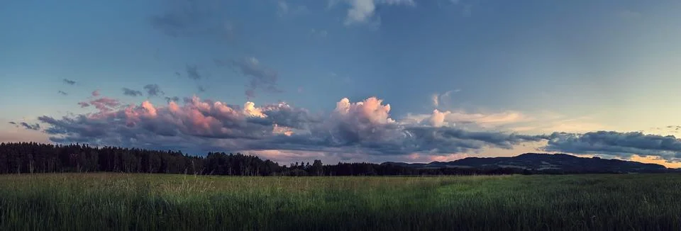 Panorama landscape at sunset - clouds illuminated by the setting sun Stock Photos