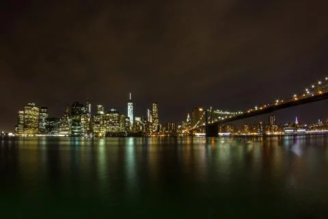 Panorama of Manhattan skyline near the Brooklyn Bridge at night Stock Photos