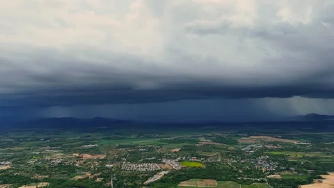 Panorama of Massive dark storm cloud expands over green farmland during monsoon 库存影片 314358184