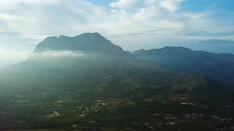 Panorama of a mountain in a cloud against sun in the background Stock Footage 239656841