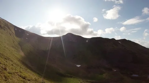 Panorama of mountain range with pieces of snow and sun with white clouds Stock Footage 40699636