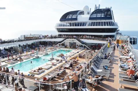 Panorama of the open deck with a luxurious pool and numerous tourists ship MS Stock Photos