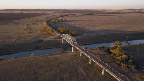 Panorama of the railway bridge over a small river flowing in the steppes Stock Footage 98096904