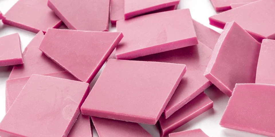 A panorama of ruby chocolate slices, a heap on a white background 写真素材