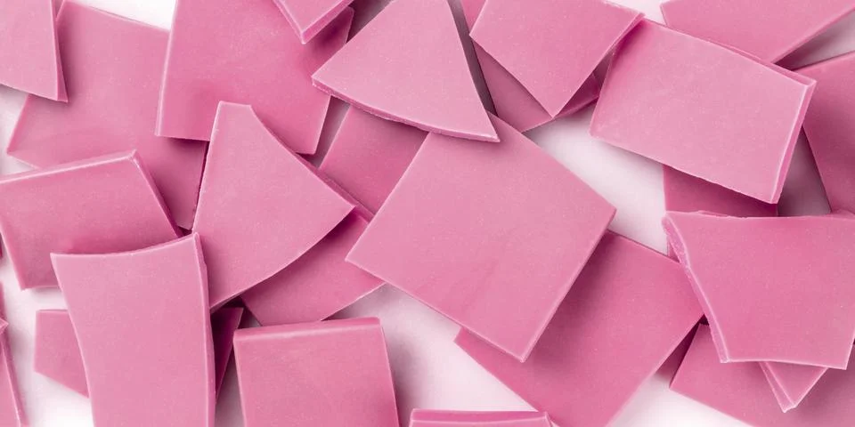 A panorama of ruby chocolate slices, overhead shot on a white marble background Foto stock