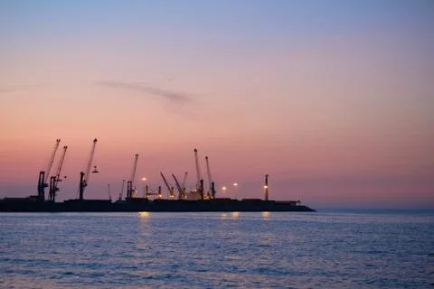 Panorama of the sea cargo port against the backdrop of the setting sun Stock Photos