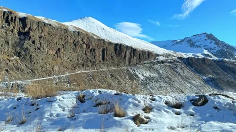 Panorama of snow-covered winter mountains captured from a moving car window Stock Footage 288401265
