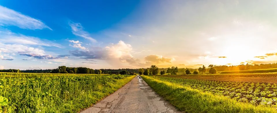 Panorama, sunset over fields and Austrian village with dramatic sky. Stock Photos