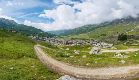 Panorama view of Alpine town surrounded with pastures. Stock Photos
