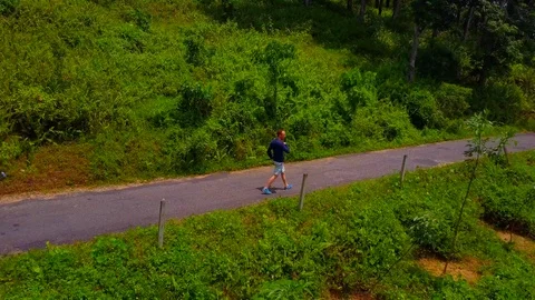 Panorama View of a man walking on a tiled road in the middle of forest Video stock 107914204