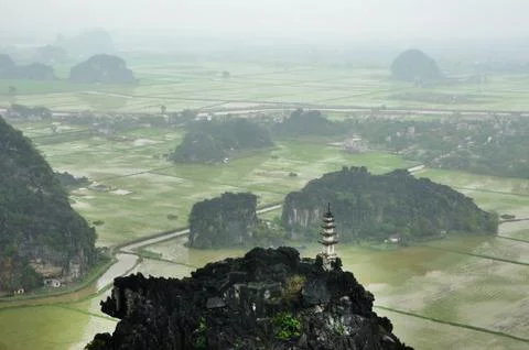 Panorama view of rice fields, rocks and mountaintop pagoda from Hang Mua Te.. Stock Photos