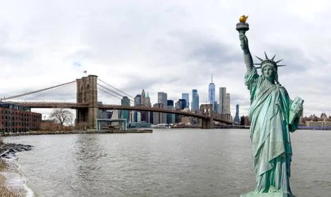 Panorama view of The Statue of Liberty with Brooklyn Bridge and Manhattan dow Stock Photos