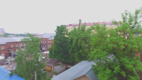 Panorama view from the window to the trees and roofs of the city. Video stock 80074987
