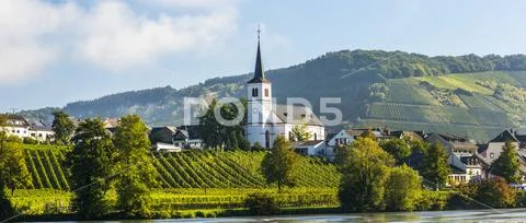 Panorama of white church in a village along a river with vineyards along riverba Stock Photos