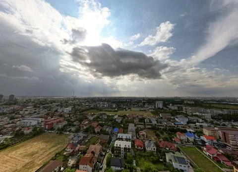 Panoramic aerial drone shot of a small city under the summer clouds. Late mid Stock Photos