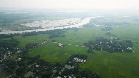 Panoramic aerial drone view of Asian farmers village and of green rice field acr Stock Footage 273632474