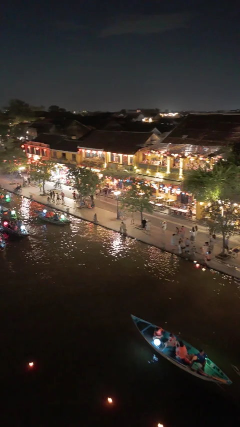 Panoramic aerial drone view of Hoi An Ancient town with boat tour in evening Video stock 289260847