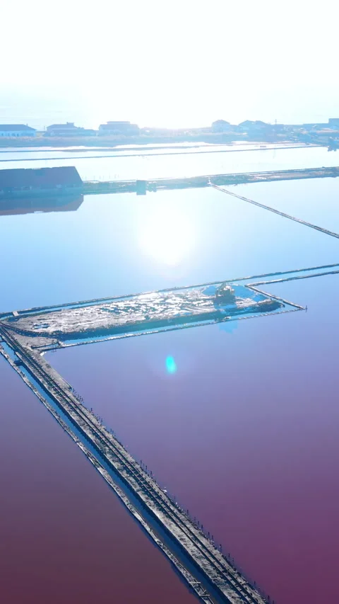 Panoramic aerial of saltern ponds with sun glare, Pomorie, Bulgaria Vertical Stock Footage 338007301