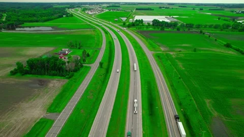 Panoramic aerial shot of Interstate 94 cutting through vibrant green Stock Footage 287200254