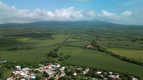 Panoramic aerial view of green crop fields and hills under clouds Stock Footage 342089189