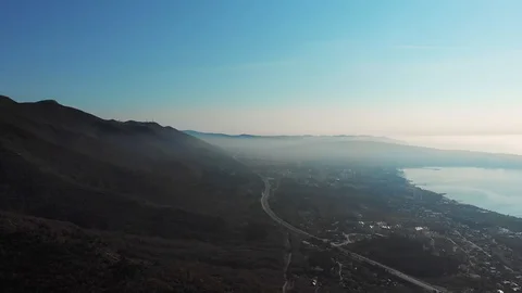 Panoramic aerial view from height of mountains in haze and the sea bay of the Stock-Footage 98359612