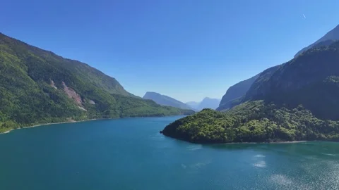 Panoramic Aerial View of Lago di Molveno Framed by Imposing Mountains in Vídeo Stock 337807644