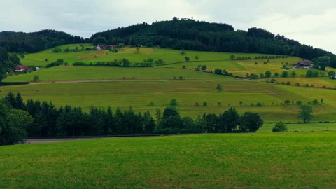 Panoramic Aerial View of Rolling Green Hills, Farmland, and Forest Village Stock Footage 338362161