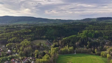 Panoramic aerial view of rolling hills, dense forests, patchwork farmland, and Stock Footage 348176643