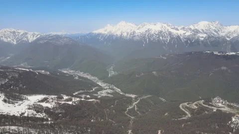 Panoramic aerial view of snow-capped mountain range in spring Stock Footage 337545082