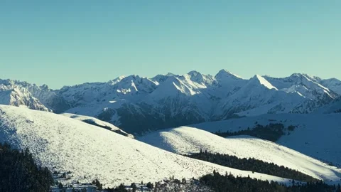 Panoramic aerial view of snow-covered mountain peaks under clear blue sky Vídeos de archivo 328301239