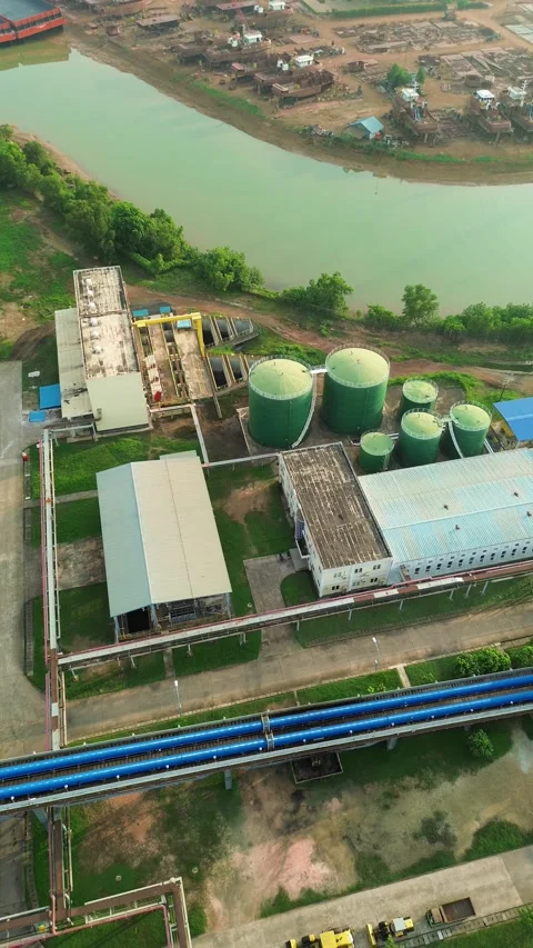 Panoramic aerial view of a sprawling industrial complex by a flowing river,.. Video stock 337281652