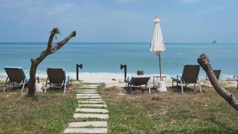Panoramic of amazing path from stones to the ocean shore with umbrellas and Stock Footage 86552454