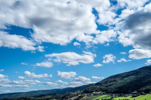 A panoramic and dramatic cloudscape with many clouds over rural landscape Stock Photos