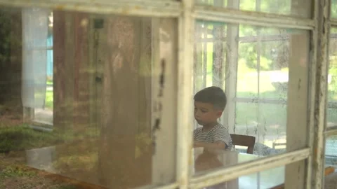 Panoramic Camera Movement Past a Young Child Typing on a Mobile Phone Stock Footage 343894320