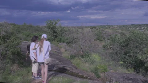 Panoramic camera movement showing a family looking at a massive rocky canyon Stock Footage 337471806