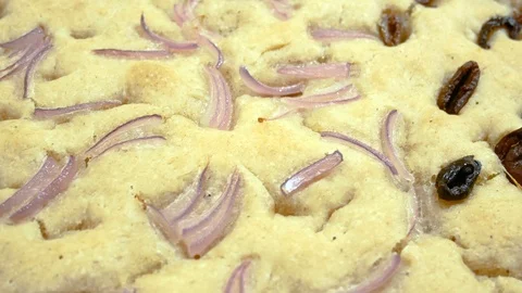 A panoramic close up of a piece of Focaccia bread with olive and onion Vídeos de archivo 87922606