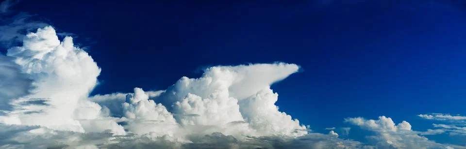 Panoramic Cloudscape in a deep blue sky Stock Photos