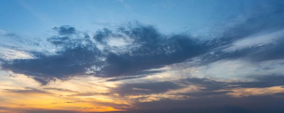 Panoramic cloudscape of dramatic blue sky and clouds at twilight Stock Photos