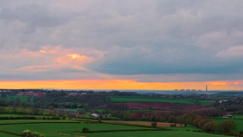 Panoramic countryside with patchwork fields and distant industrial plant under Stock-Footage 332219168