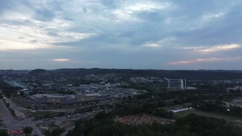 Panoramic drone flight reveals a sprawling city transitioning from daylight Stock Footage 320064206