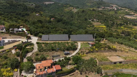 Panoramic drone shot around a solar panel array on a rural hillside in Liguria Video stock 338159036