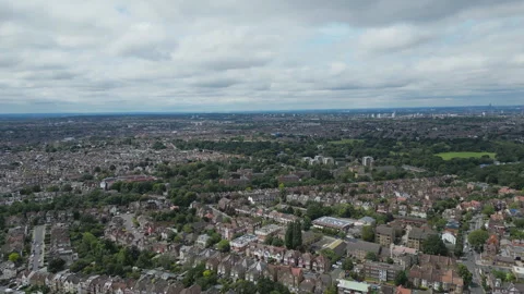 Panoramic drone shot of a dense suburban area with greenery under a cloudy sky. Stock Footage 297960255