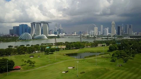 Panoramic drone shot of green golf course lawn and modern skyline of Singapore Vídeos de archivo 78585003